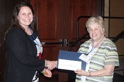 Heartland Community College student Sara Keene (left) accepts her $250 Paul Simon Student Essay Contest scholarshipfrom ICCTA secretary Kathy Spears.