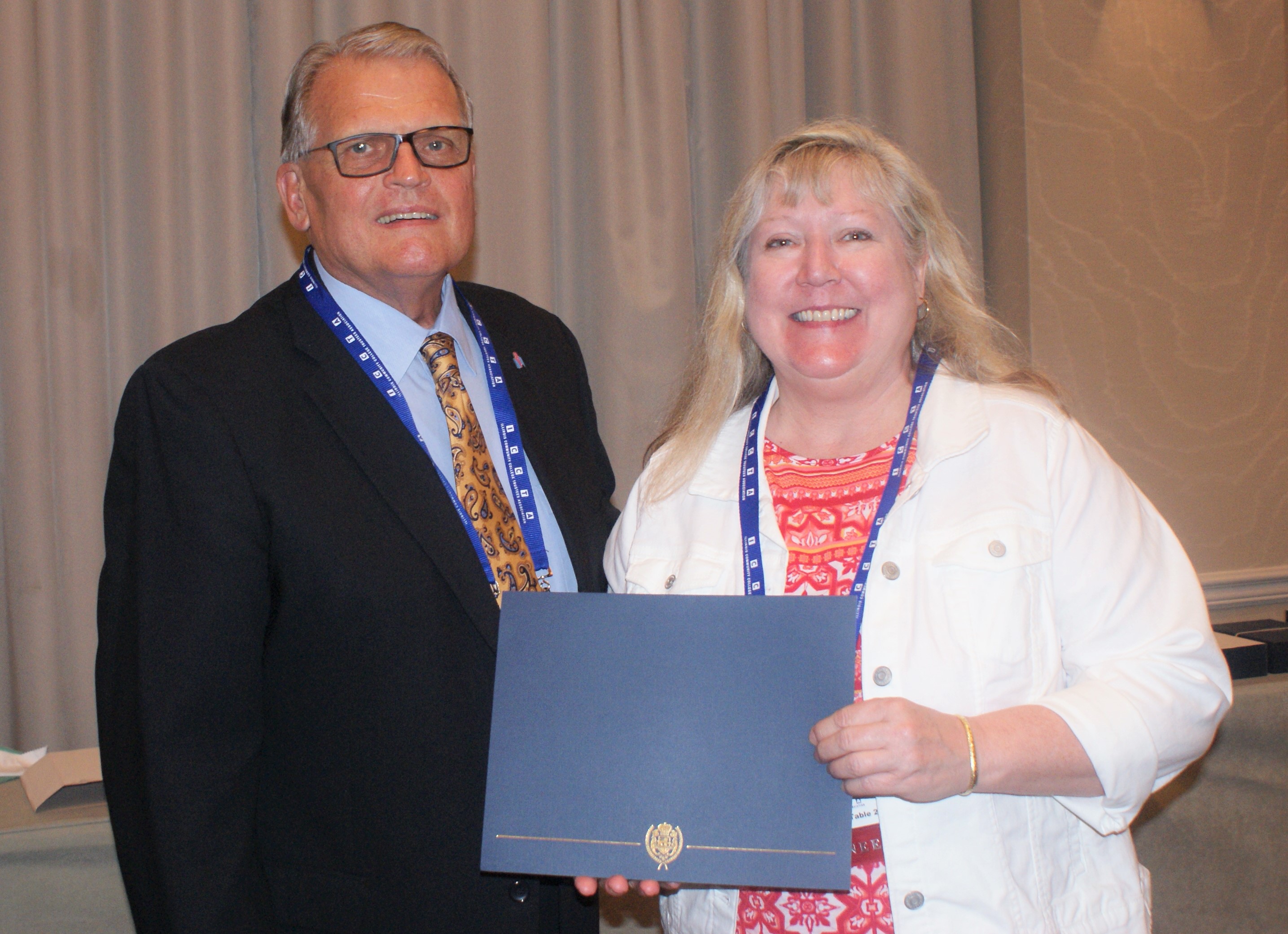 McHenry County College student Karen Russ accepts her $500 Paul Simon Student Essay Contest scholarshipfrom Illinois Community College System Foundation president Dr. Joe Kanosky.