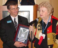 Oakton trustee Joan B. Hall accepts her 2005 Ray Hartstein Trustee Achievement Award from ICCTA vice president Tom Bennett.