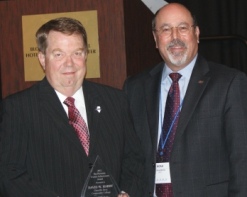 Danville Area Community College trustee David W. Harby (left) receives ICCTA's 2012 Ray Hartstein Trustee Achievement Award from Association of Community College Trustees president/CEO Noah Brown.