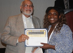 John A. Logan College student Jor'Dan Crim accepts her $1,000 Gandhi/King Peace Essay Scholarshipfrom Oakton Community College trustee emeritus Jody Wadhwa.